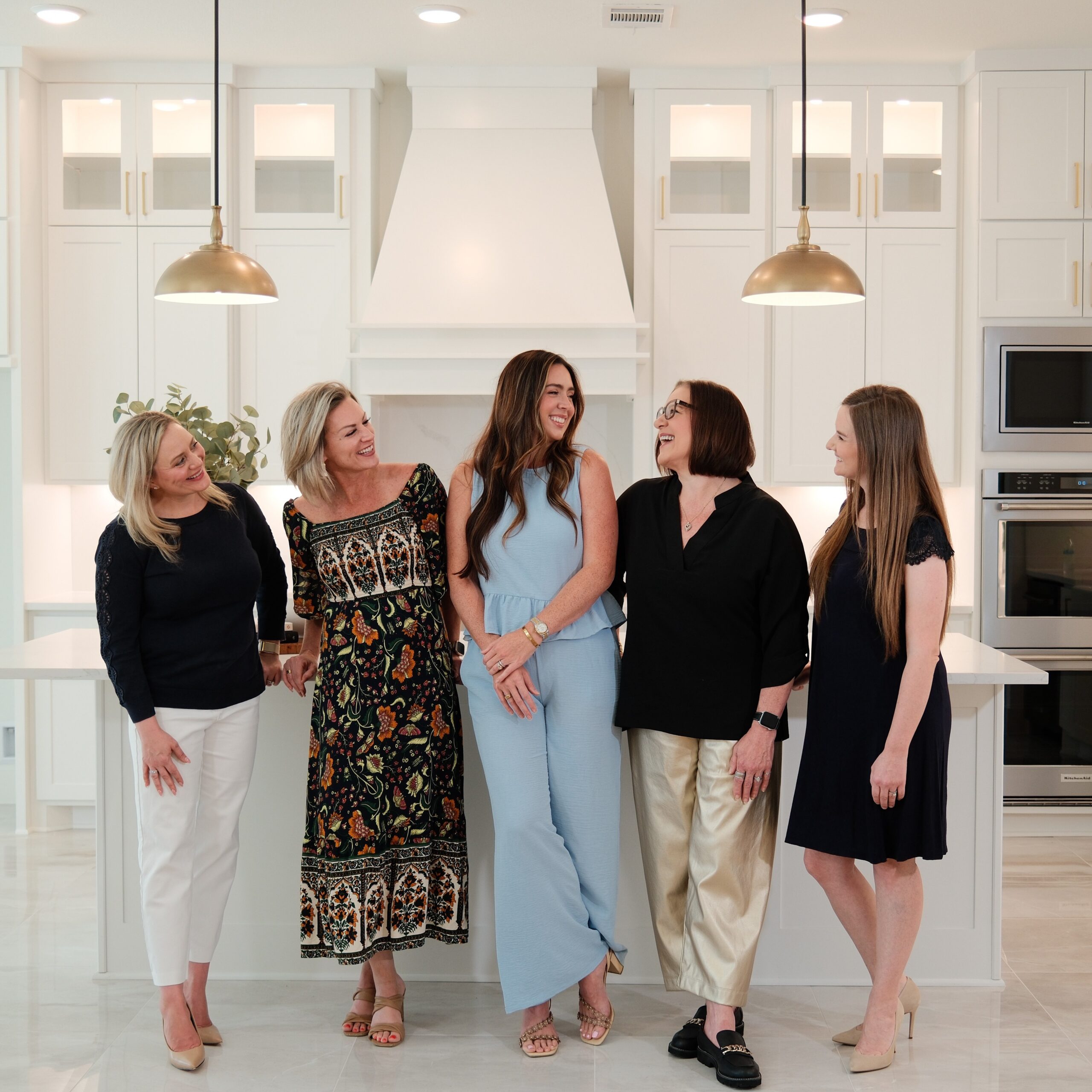 The Jamie McMartin Group team in a bright modern kitchen, ready to help you sell your Katy home.