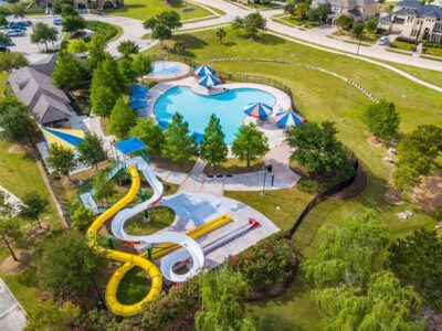 Resort-style community pool with a water slide in Cinco Ranch, a popular amenity for buyers moving to Katy, TX.