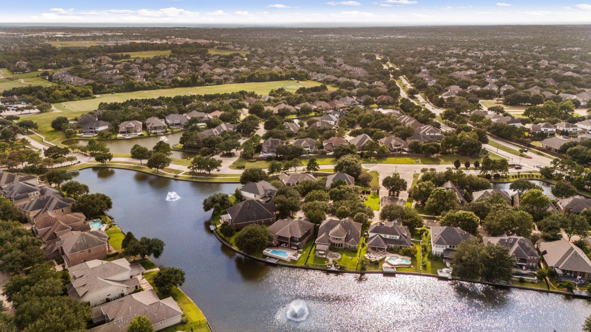 Aerial view of a Katy master-planned community with lakes, trails, and family homes