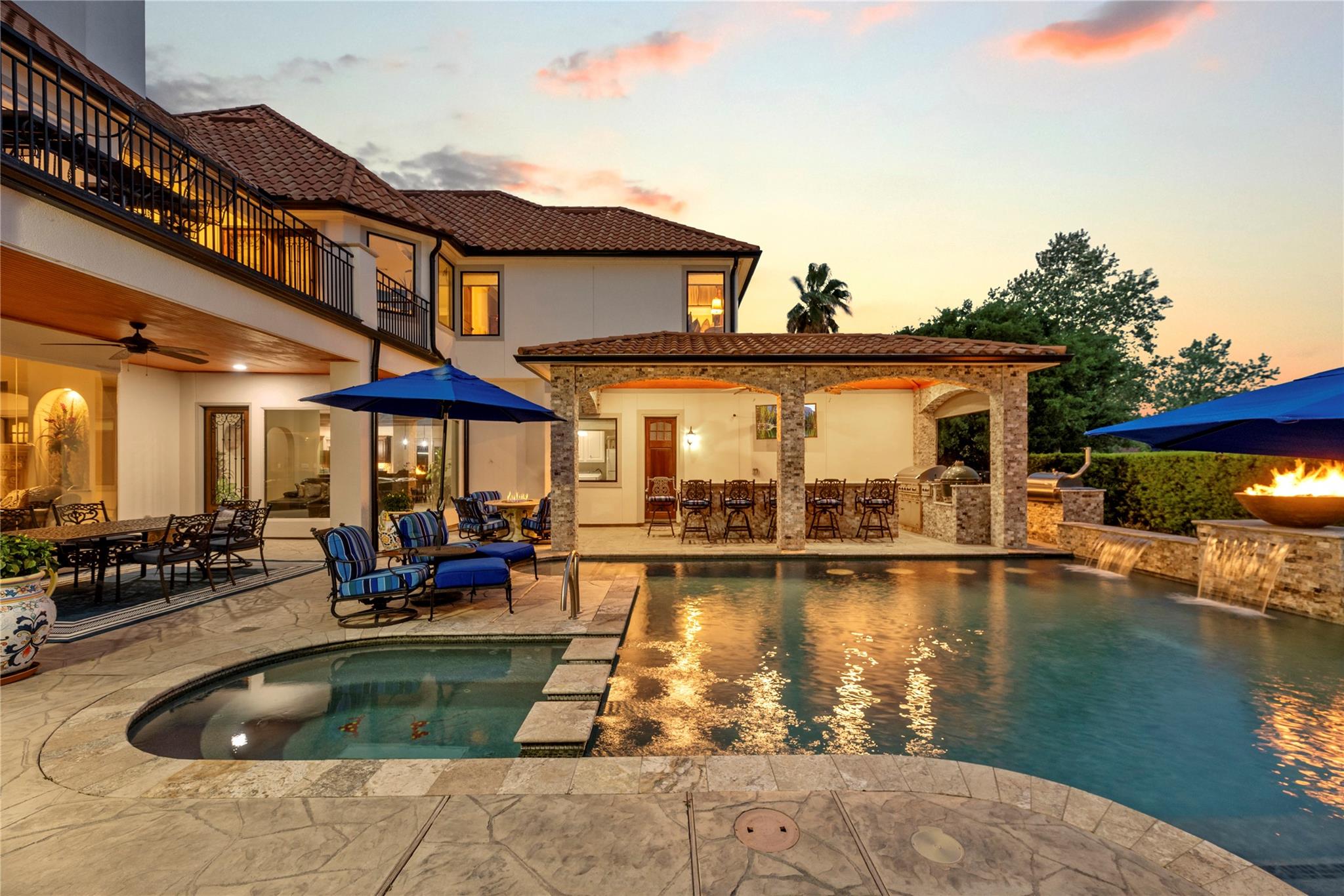 Heated gunite pool and spa with a lakefront backdrop and tanning ledge — the kind of resort-style outdoor living that helps when you sell my Houston home