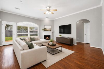 An open-concept living area with engineered wood floors flowing into the kitchen, ideal for a smaller home when downsizing in Katy or Fulshear.
