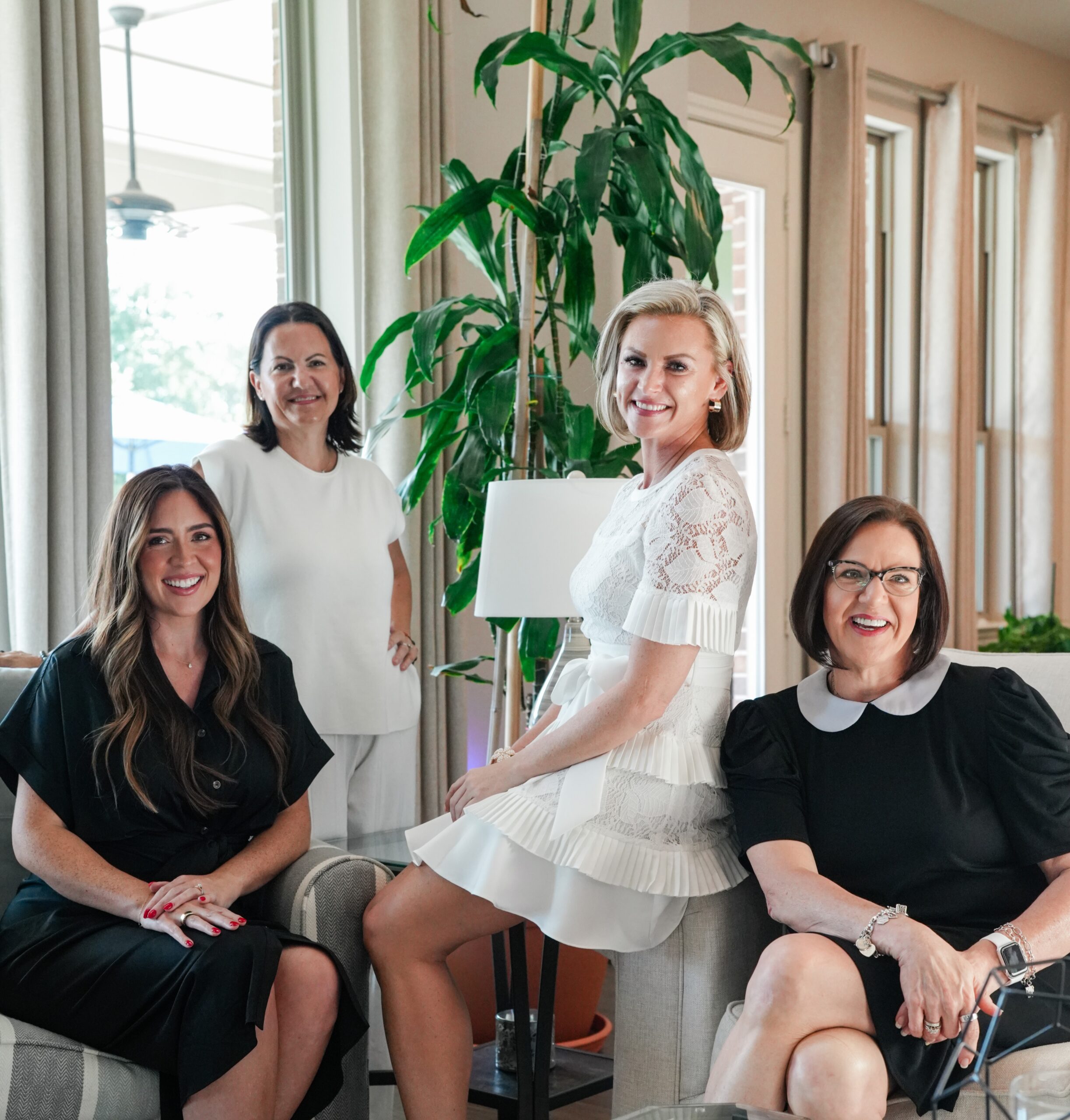 Four members of The Jamie McMartin Group smiling together during a team gathering.