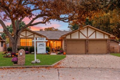 Buying a house in Katy this fall, featuring a for-sale sign surrounded by seasonal autumn landscaping.