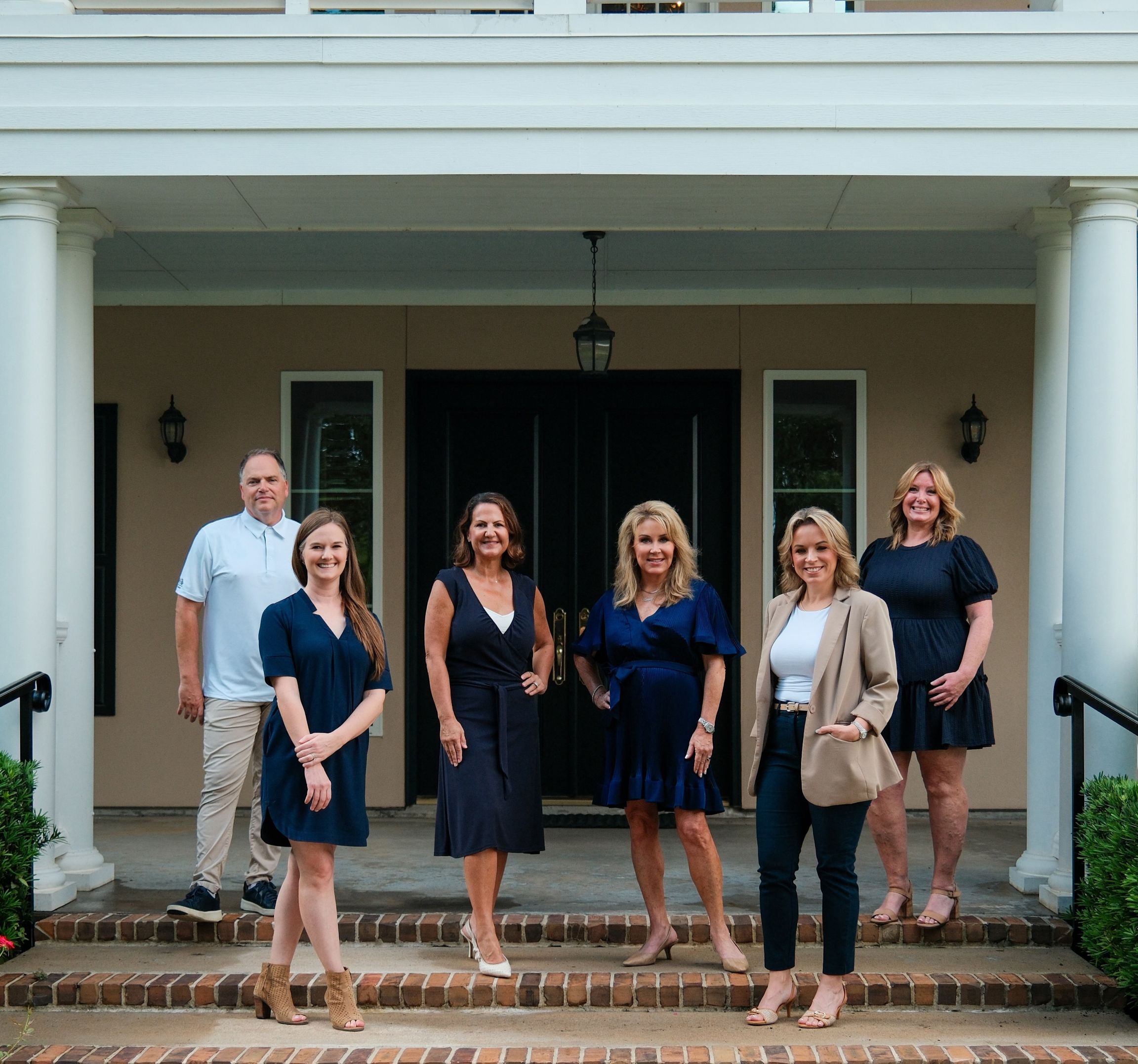 The Jamie McMartin Group team, your source for the latest Houston real estate market update, outside a Houston-area home.